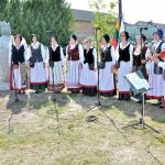 Prie paminklo dainuoja